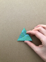 Step 4 medusa kusudama: Fold the diamond in half then fold the top point to the right corner.