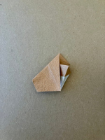 Step 10 16 piece modular pinwheel: Tuck the left flap under and fold the right flap backward.